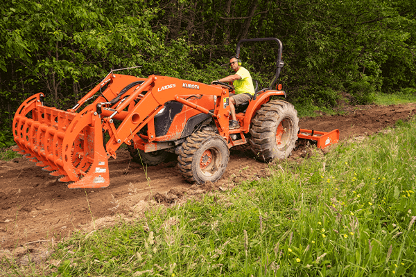 Two Homestead Implements attachments on a tractor, a land plane and root grapple